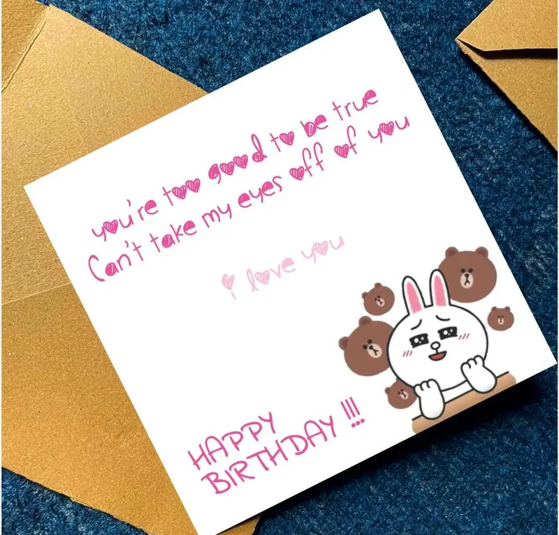 A white birthday card with pink handwritten text and a cartoon illustration. The text reads "you're 