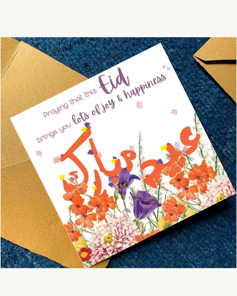 A white greeting card with the word "Eid" in purple script and orange Arabic calligraphy. The card i