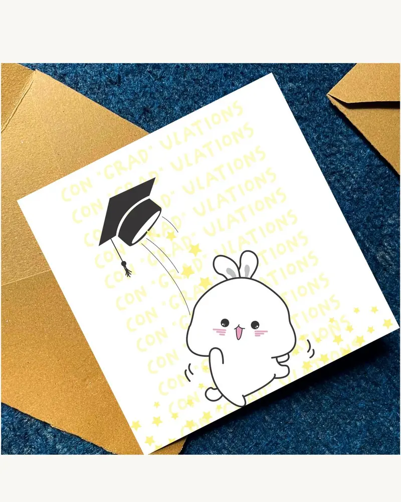 A graduation card featuring a cartoon bunny and mortarboard illustration. The card has the words "CO