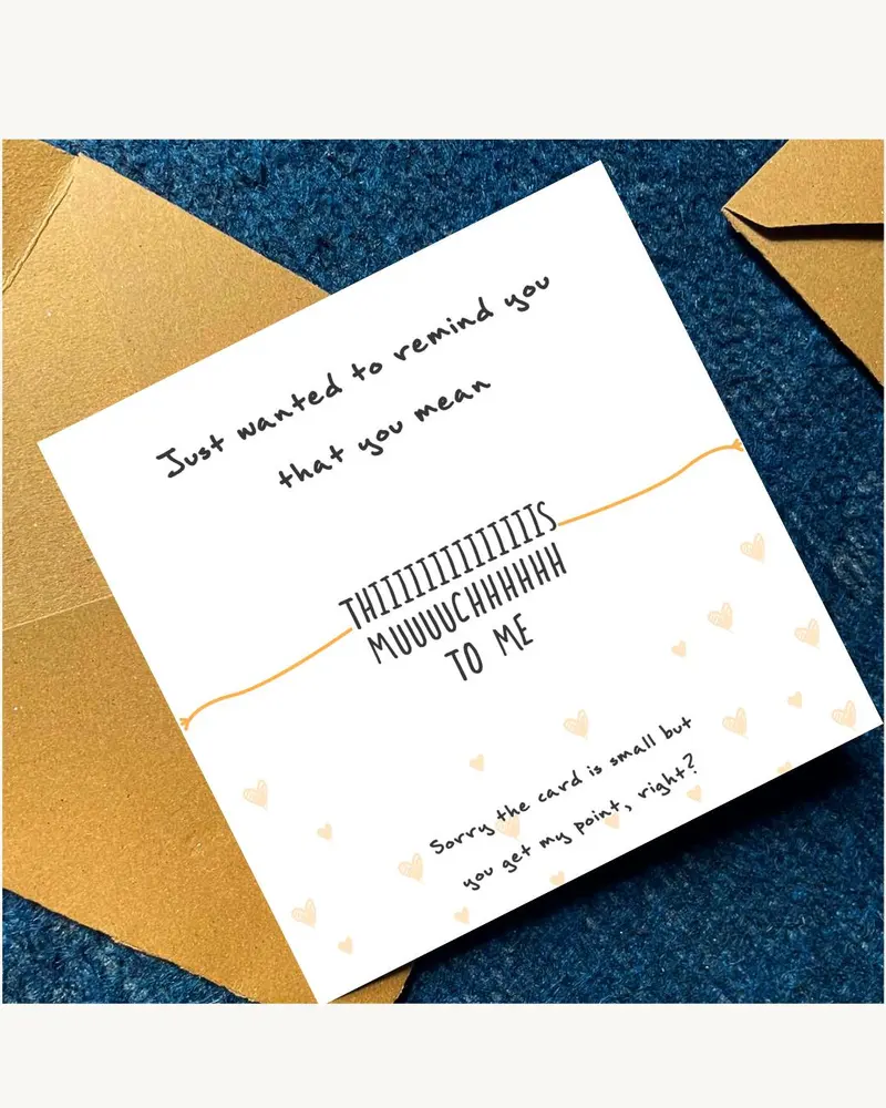 A white card with the text "Just wanted to remind you that you mean THIIIIIIIIIIIIIIS MUUUUCHHHHHH T