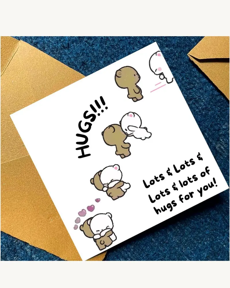 A white greeting card with the words "HUGS!!!" and "Lots & Lots & Lots & lots of hugs for you!" in b