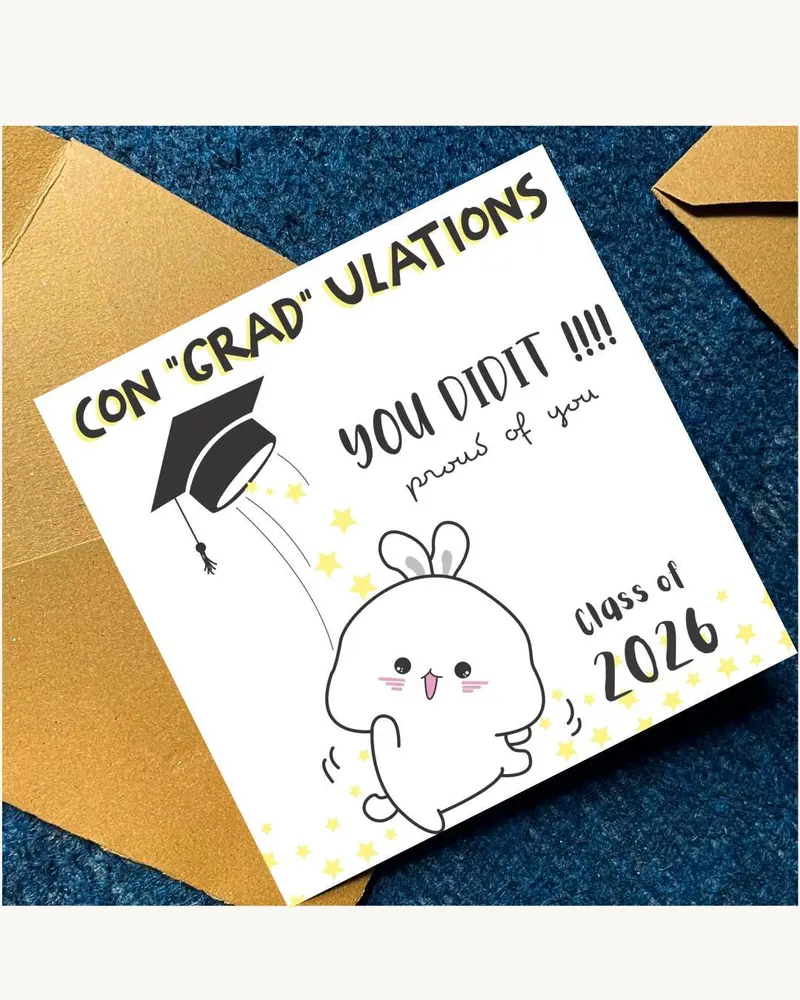 A graduation card with the text "CON 'GRAD' ULATIONS" and "YOU DID IT!!!! proud of you". The card fe