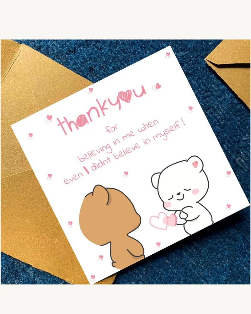 A square white greeting card featuring a brown bear and a white bear with pink hearts. The text read